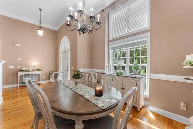 4322 Wellesley Dr, Ooltewah, TN 37363 - dining space with high vaulted ceiling, a chandelier, ornamental molding, light wood-style flooring, and baseboards