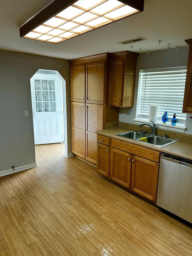219 Igou Ferry Rd, Soddy Daisy, TN 37379 - kitchen featuring a sink, stainless steel dishwasher, light wood finished floors, brown cabinetry, and arched walkways