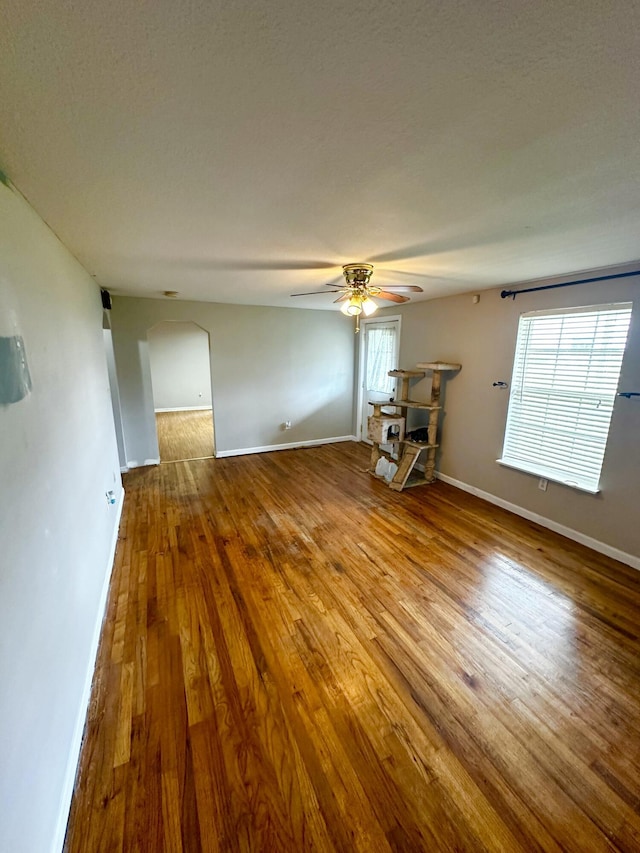 219 Igou Ferry Rd, Soddy Daisy, TN 37379 - unfurnished room featuring arched walkways, ceiling fan, hardwood / wood-style flooring, and baseboards