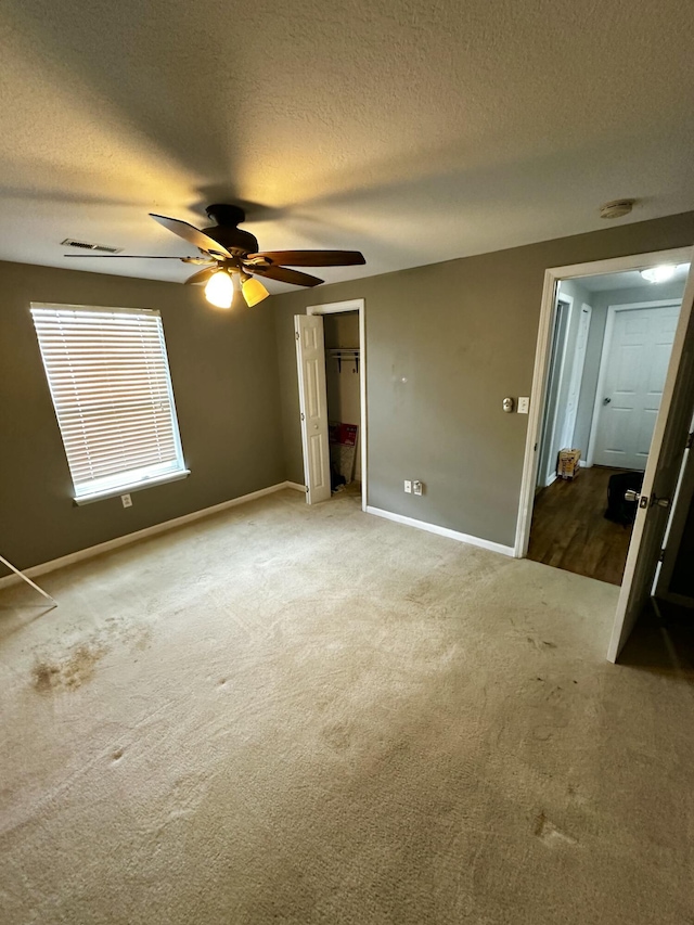219 Igou Ferry Rd, Soddy Daisy, TN 37379 - unfurnished bedroom featuring carpet floors, baseboards, a textured ceiling, a closet, and a ceiling fan