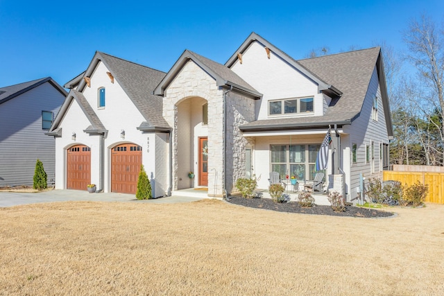 8870 Silver Maple Dr, Ooltewah, TN 37363 - view of front of property featuring a porch, driveway, a garage, stone siding, and a shingled roof