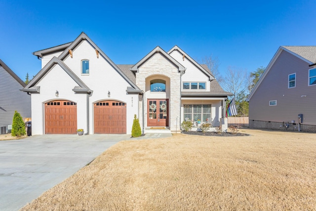 8870 Silver Maple Dr, Ooltewah, TN 37363 - french provincial home with french doors, driveway, stone siding, a front lawn, and an attached garage
