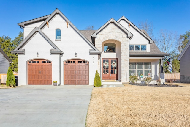 8870 Silver Maple Dr, Ooltewah, TN 37363 - french country inspired facade with concrete driveway, french doors, a front lawn, brick siding, and stone siding