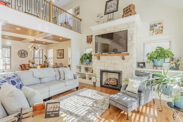8870 Silver Maple Dr, Ooltewah, TN 37363 - living room featuring a stone fireplace, wood finished floors, a chandelier, recessed lighting, and a high ceiling