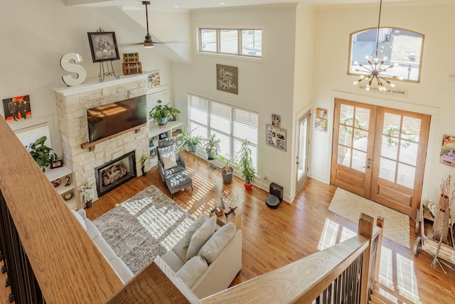 8870 Silver Maple Dr, Ooltewah, TN 37363 - living area featuring a fireplace, a towering ceiling, ceiling fan, wood finished floors, and baseboards