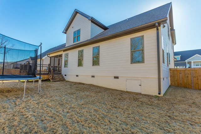 8870 Silver Maple Dr, Ooltewah, TN 37363 - back of property with crawl space, a trampoline, a deck, and roof with shingles