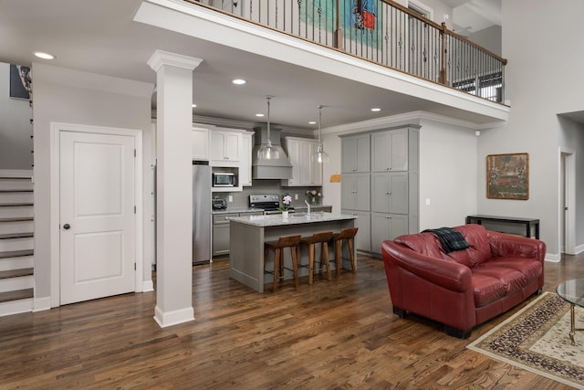 1676 Westover Ln, Chattanooga, TN 37405 - kitchen with stainless steel appliances, premium range hood, gray cabinetry, a kitchen bar, and open floor plan