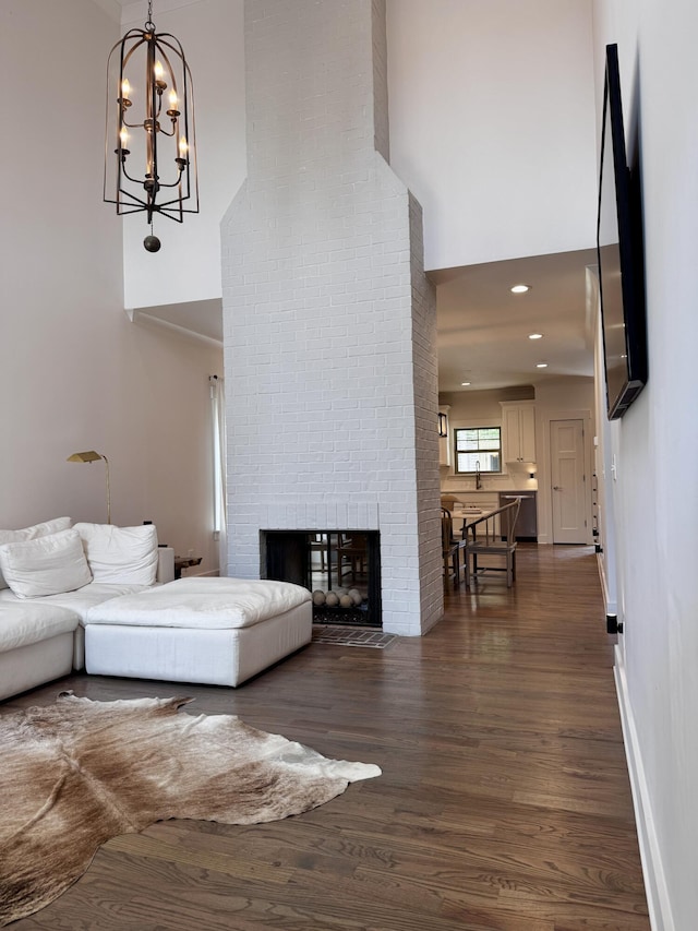 2617 Wendell Way, Chattanooga, TN 37421 - living area with a high ceiling, dark wood finished floors, a brick fireplace, baseboards, and a chandelier