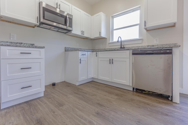 4327 Cronan Dr, Cohutta, GA 30710 - kitchen featuring appliances with stainless steel finishes, light wood-type flooring, white cabinetry, and light stone counters
