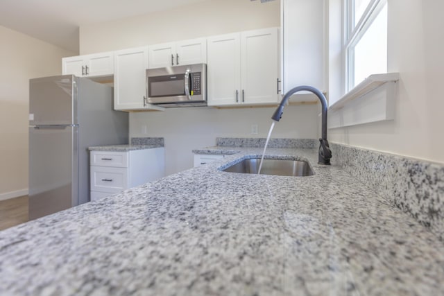 4327 Cronan Dr, Cohutta, GA 30710 - kitchen featuring stainless steel microwave, freestanding refrigerator, light stone counters, and white cabinets