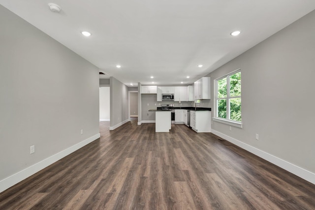 6009 Arlena Cir, Chattanooga, TN 37421 - unfurnished living room featuring baseboards, recessed lighting, dark wood-style floors, and a sink