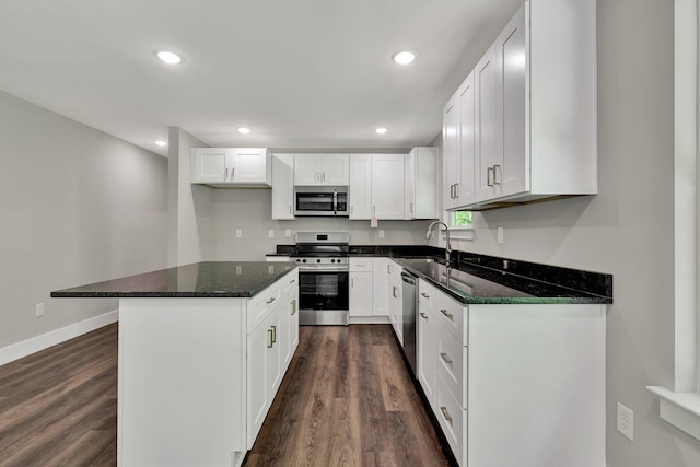 6009 Arlena Cir, Chattanooga, TN 37421 - kitchen with stainless steel appliances, a sink, a kitchen island, white cabinets, and dark wood finished floors