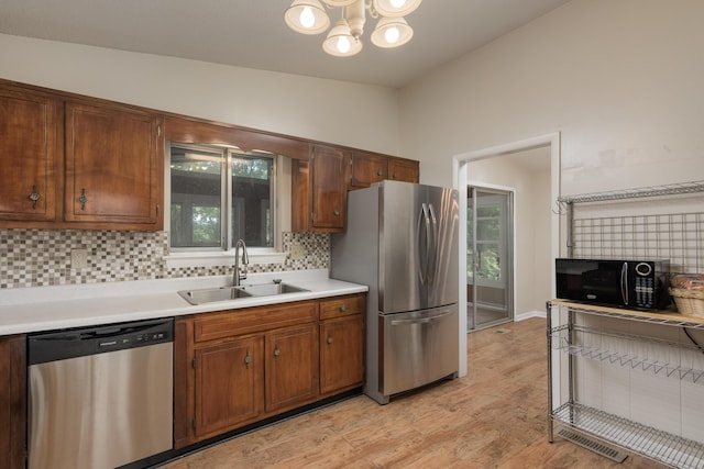 7335 Valley Ln, Hixson, TN 37343 - kitchen featuring appliances with stainless steel finishes, a sink, decorative backsplash, light countertops, and a chandelier
