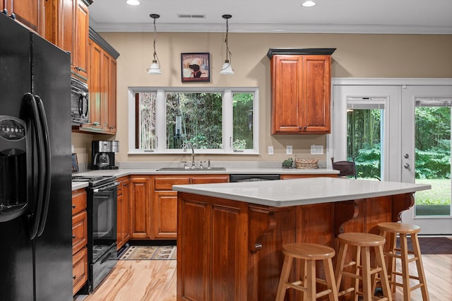 204 Chapman Ct, Lafayette, GA 30728 - kitchen with black appliances, light wood finished floors, a kitchen island, brown cabinetry, and crown molding
