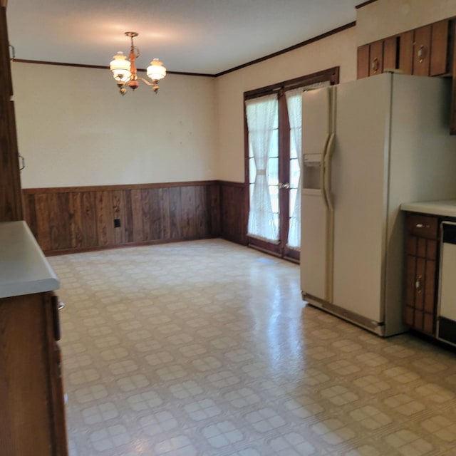 1030 Ambrose Ln, Hixson, TN 37343 - unfurnished dining area featuring a chandelier, wooden walls, a wainscoted wall, crown molding, and light floors