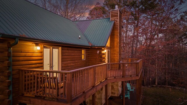 292 Log Cabin Ln Unit 14, Dunlap, TN 37327 - back of house at dusk with a chimney, a deck, log exterior, and metal roof