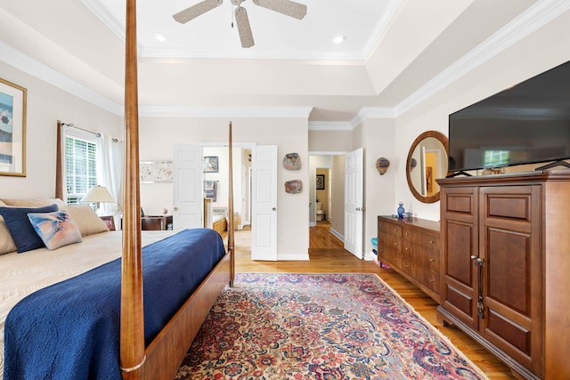 902 Cattails Dr, Ooltewah, TN 37363 - bedroom with a tray ceiling, light wood-type flooring, crown molding, ceiling fan, and baseboards