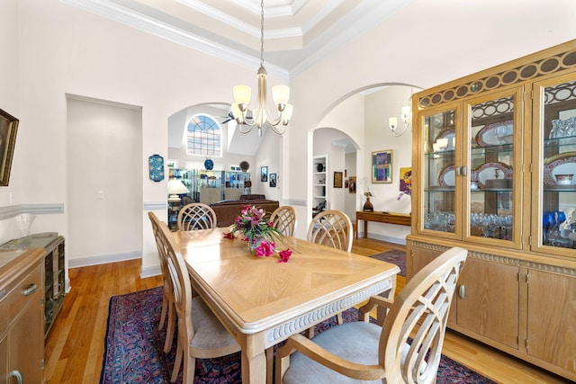 902 Cattails Dr, Ooltewah, TN 37363 - dining room featuring arched walkways, a chandelier, ornamental molding, and light wood-type flooring