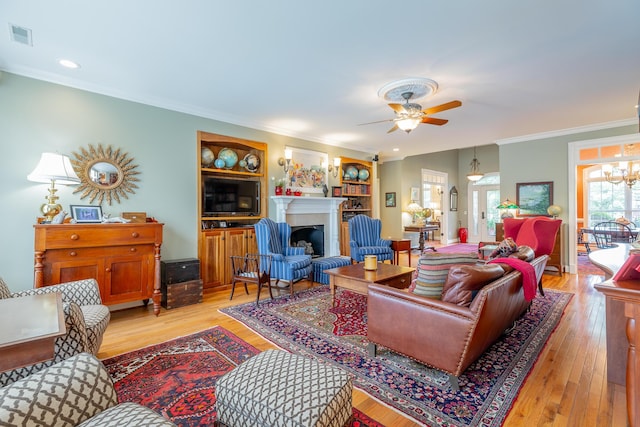 9548 Shadow Crossing Ln, Chattanooga, TN 37421 - living area featuring crown molding, a ceiling fan, a fireplace, light wood-style flooring, and a chandelier