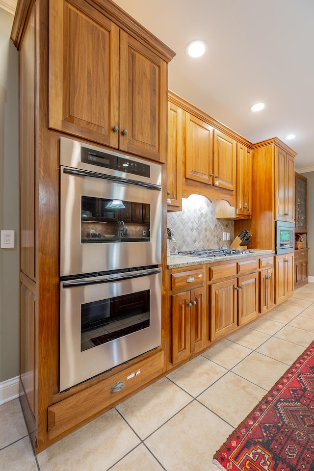 9548 Shadow Crossing Ln, Chattanooga, TN 37421 - kitchen with appliances with stainless steel finishes, light tile patterned floors, tasteful backsplash, light stone countertops, and brown cabinets