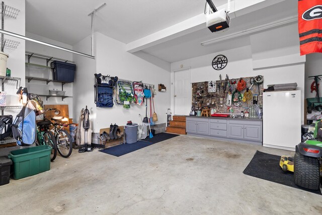102 Water Mill Trce, Ringgold, GA 30736 - garage featuring a garage door opener, a workshop area, and freestanding refrigerator