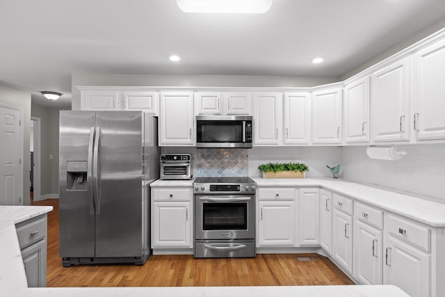 102 Water Mill Trce, Ringgold, GA 30736 - kitchen with stainless steel appliances, light wood finished floors, light countertops, backsplash, and recessed lighting