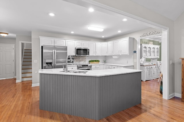 102 Water Mill Trce, Ringgold, GA 30736 - kitchen featuring appliances with stainless steel finishes, white cabinets, an island with sink, tasteful backsplash, and light countertops