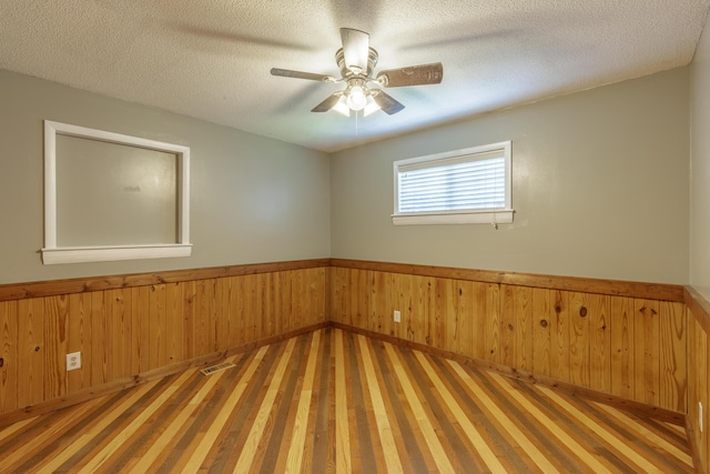 252 Valley View Dr, Dunlap, TN 37327 - spare room with wood finished floors, wainscoting, a textured ceiling, wooden walls, and a ceiling fan