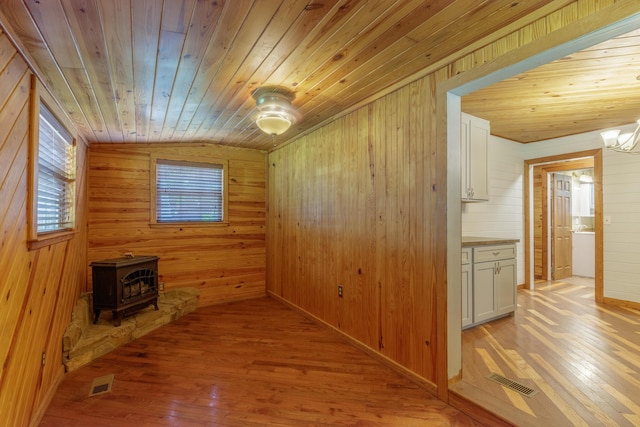 252 Valley View Dr, Dunlap, TN 37327 - empty room featuring wooden walls, a wood stove, wooden ceiling, light wood-style floors, and lofted ceiling