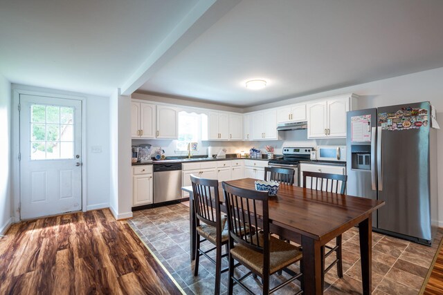 300 Bronco Rd, Lafayette, GA 30728 - kitchen with stainless steel appliances, a sink, under cabinet range hood, dark countertops, and white cabinetry