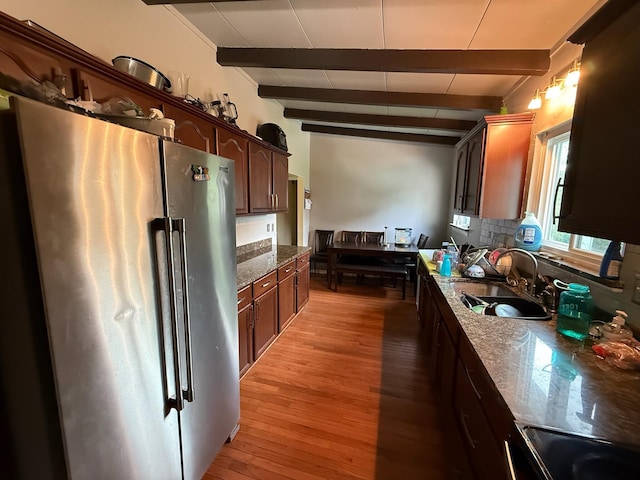 4509 Dumac Rd, Chattanooga, TN 37416 - kitchen featuring freestanding refrigerator, beam ceiling, light wood finished floors, dark brown cabinetry, and decorative backsplash