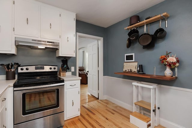 3606 Gleason Dr, Chattanooga, TN 37412 - kitchen with electric range, under cabinet range hood, light wood-style flooring, white cabinets, and light countertops