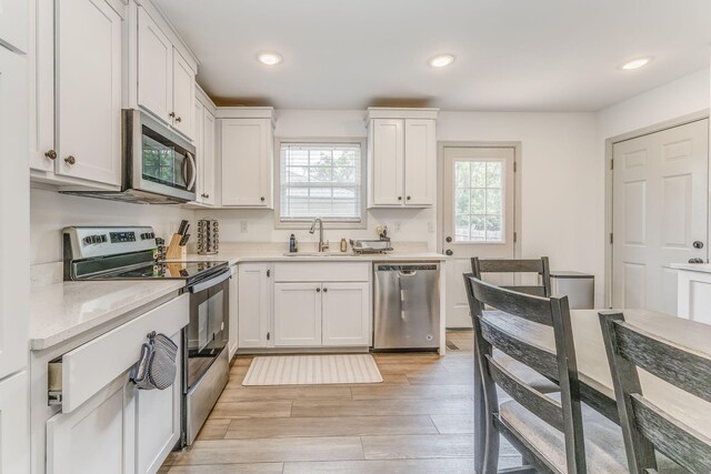 2091 Hummingbird Dr, Dalton, GA 30721 - kitchen featuring stainless steel appliances, white cabinetry, light wood-style floors, and recessed lighting