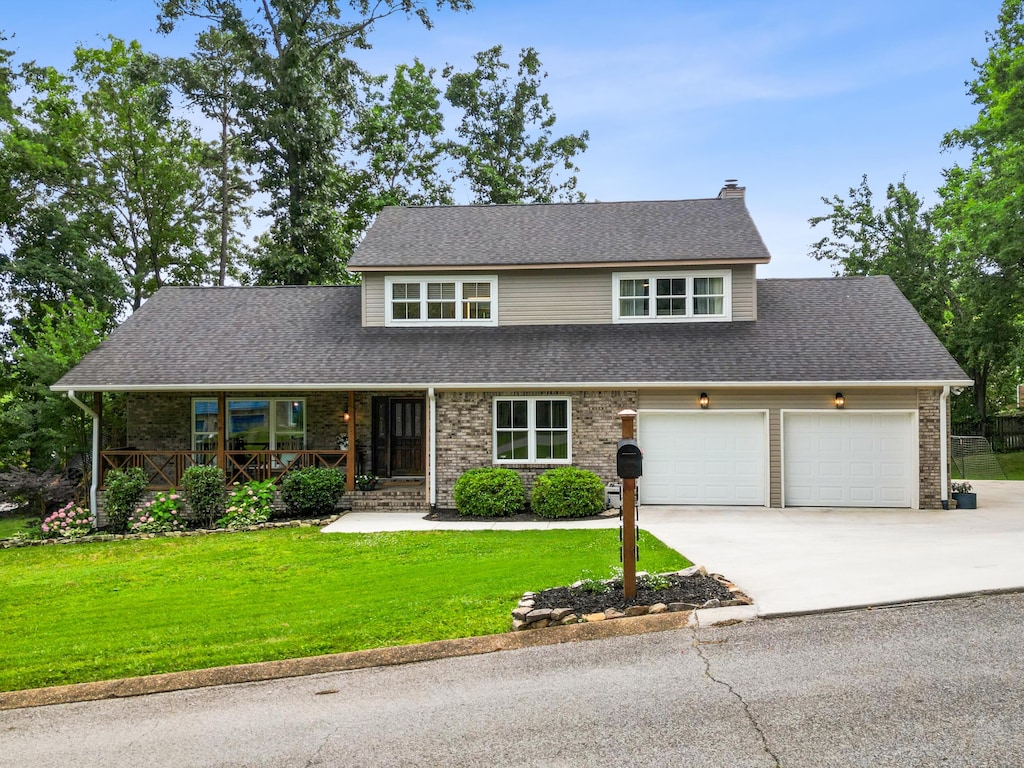 8708 Misty Hollow Ln, Chattanooga, TN 37421 - traditional-style house featuring a porch, a front lawn, a chimney, driveway, and brick siding