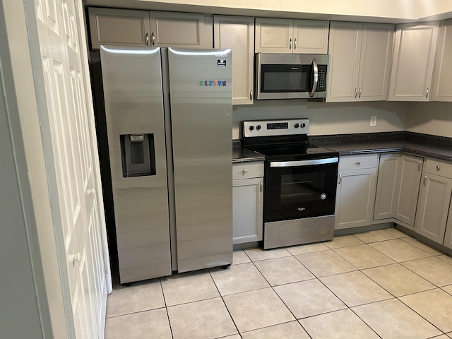 3955 Teakwood Dr, Chattanooga, TN 37416 - kitchen with appliances with stainless steel finishes, dark countertops, light tile patterned floors, and gray cabinetry
