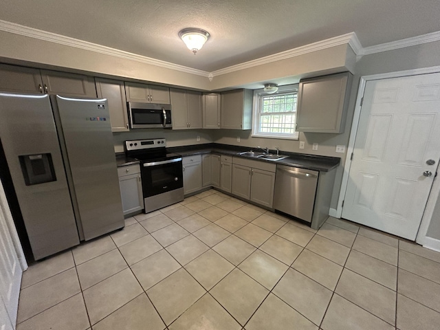 3955 Teakwood Dr, Chattanooga, TN 37416 - kitchen with appliances with stainless steel finishes, gray cabinets, dark countertops, a sink, and crown molding