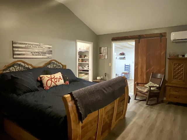 690 Ditch Gap Rd, Whitwell, TN 37397 - bedroom featuring a wall unit AC, wood finished floors, vaulted ceiling, and a barn door
