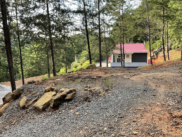 690 Ditch Gap Rd, Whitwell, TN 37397 - view of front of house with metal roof, a view of trees, and an outbuilding