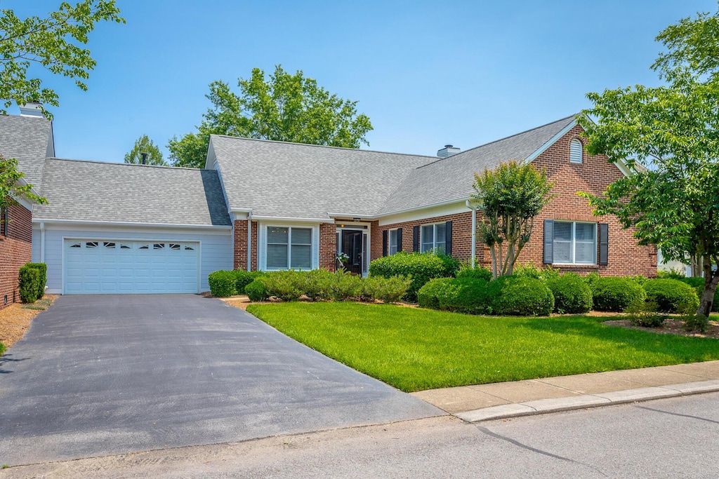1099 Constitution Dr, Chattanooga, TN 37405 - view of front of property featuring brick siding, a garage, asphalt driveway, and a front lawn
