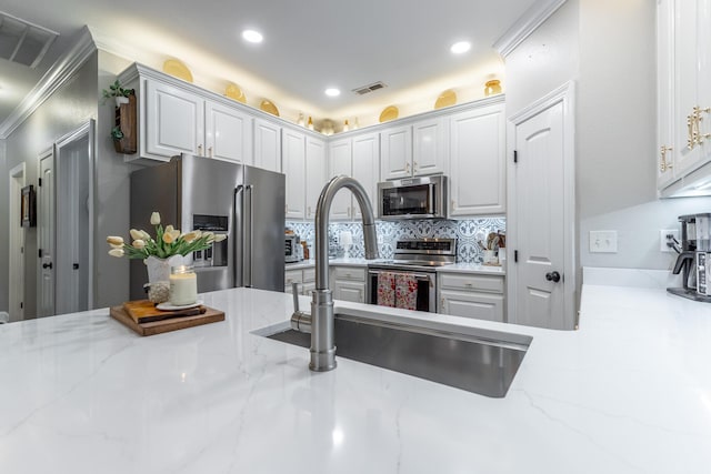 2311 Waterhaven Dr, Chattanooga, TN 37406 - kitchen featuring appliances with stainless steel finishes, backsplash, white cabinetry, recessed lighting, and light stone countertops