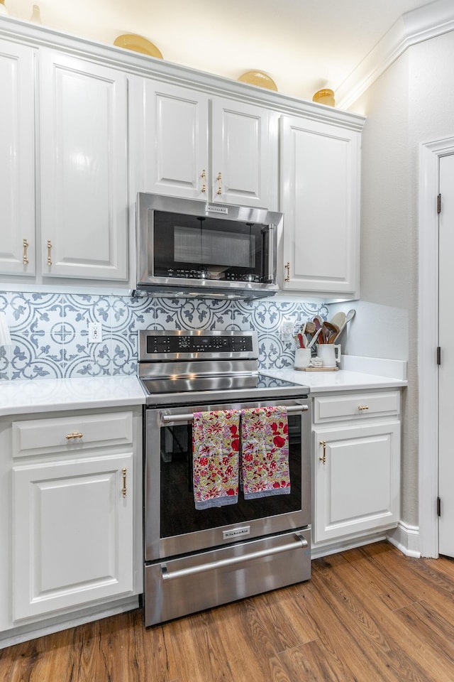 2311 Waterhaven Dr, Chattanooga, TN 37406 - kitchen featuring appliances with stainless steel finishes, light countertops, decorative backsplash, white cabinetry, and wood finished floors