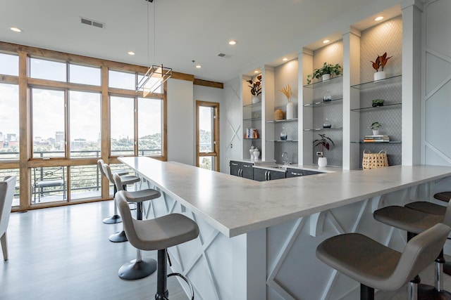 200 Manufacturers Rd Apt 507, Chattanooga, TN 37405 - kitchen with open shelves, a kitchen bar, wood finished floors, a peninsula, and recessed lighting