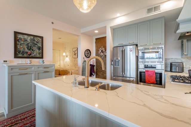 200 Manufacturers Rd Apt 507, Chattanooga, TN 37405 - kitchen featuring appliances with stainless steel finishes, light stone countertops, custom exhaust hood, decorative backsplash, and recessed lighting