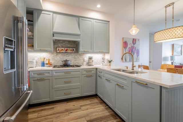 200 Manufacturers Rd Apt 507, Chattanooga, TN 37405 - kitchen with high end fridge, a peninsula, light stone counters, decorative backsplash, and light wood-type flooring