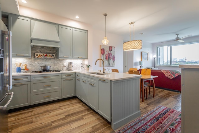 200 Manufacturers Rd Apt 507, Chattanooga, TN 37405 - kitchen featuring a peninsula, light wood-style floors, decorative backsplash, gray cabinetry, and recessed lighting