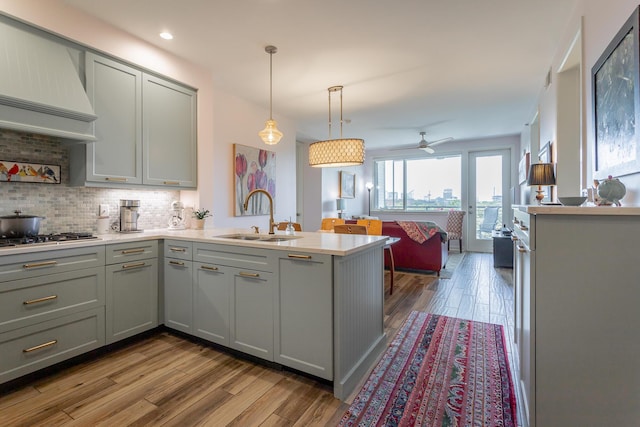 200 Manufacturers Rd Apt 507, Chattanooga, TN 37405 - kitchen featuring gray cabinets, a peninsula, wood finished floors, custom exhaust hood, and light countertops