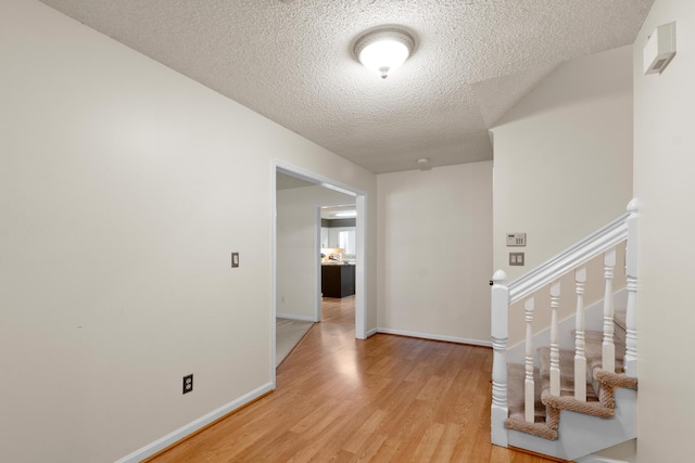 6590 Hickory Brook Rd, Chattanooga, TN 37421 - corridor featuring light wood-style flooring, a textured ceiling, and baseboards
