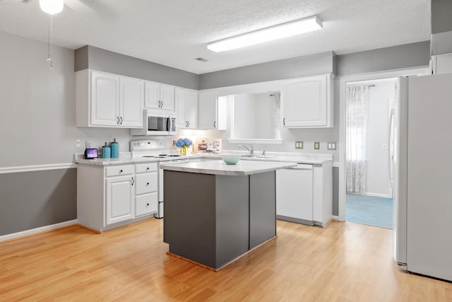 6590 Hickory Brook Rd, Chattanooga, TN 37421 - kitchen featuring white appliances, white cabinetry, light countertops, light wood-style floors, and a kitchen island