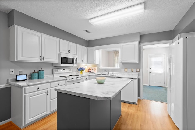 6590 Hickory Brook Rd, Chattanooga, TN 37421 - kitchen featuring white appliances, a sink, light countertops, white cabinetry, and a kitchen island