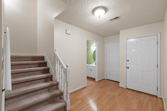 6590 Hickory Brook Rd, Chattanooga, TN 37421 - entryway with light wood-style floors, stairway, a textured ceiling, and baseboards